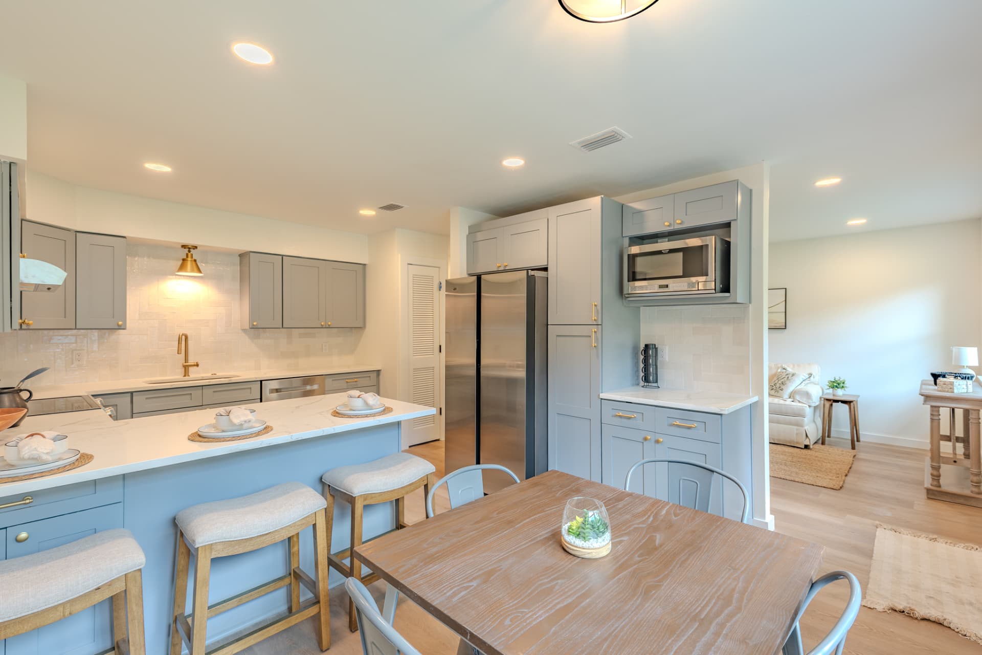 Open kitchen and dining area with grey shaker cabinetry, quartz island, and counter stools on Vernon Street