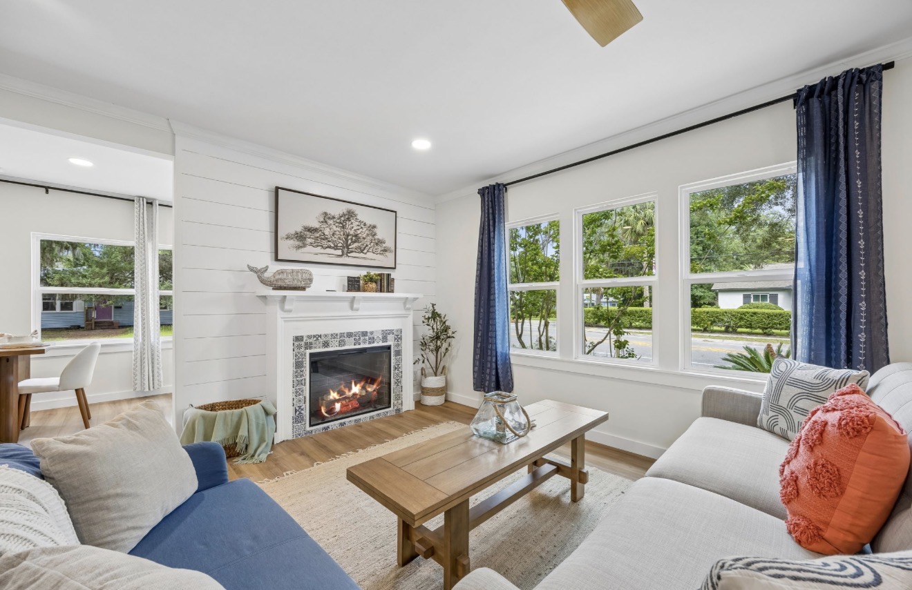Living room staged with a blue and cream sectional, wood coffee table, and tiled shiplap fireplace at 14th Street