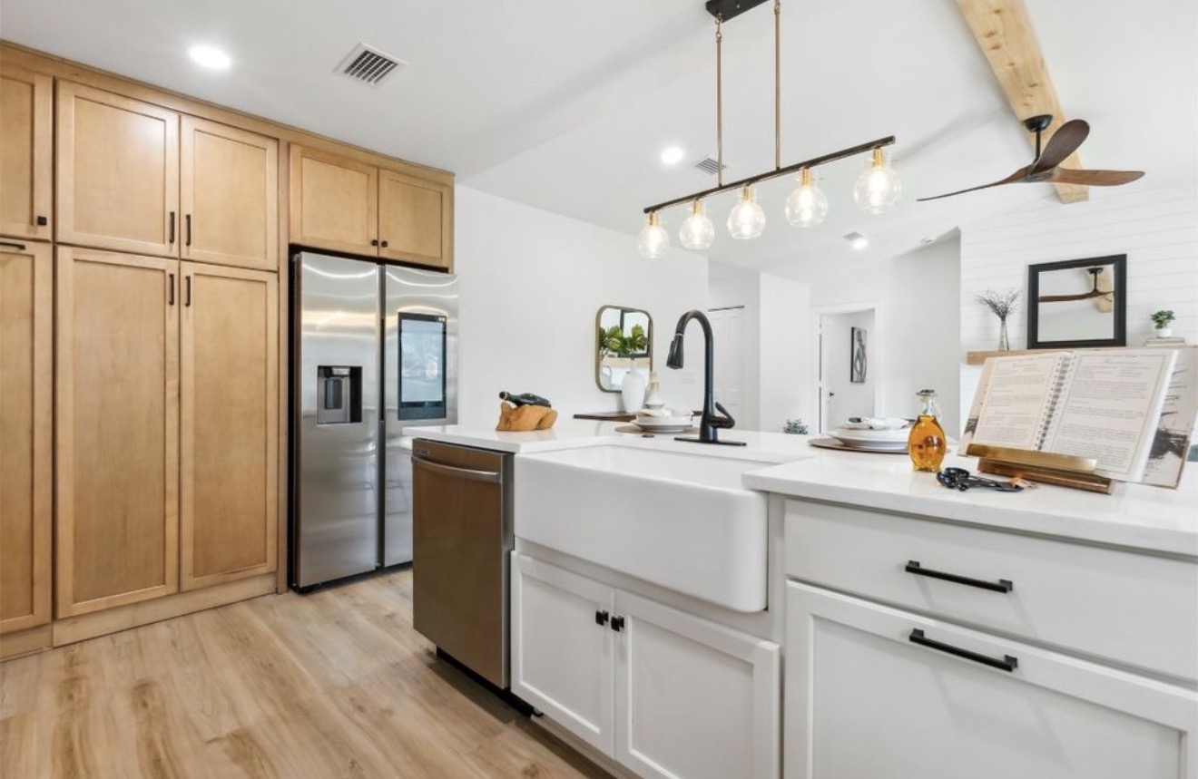 Kitchen with natural maple cabinetry, farmhouse sink, and matte black fixtures