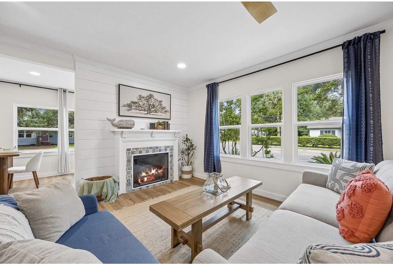 Staged coastal living room with shiplap fireplace and navy accents