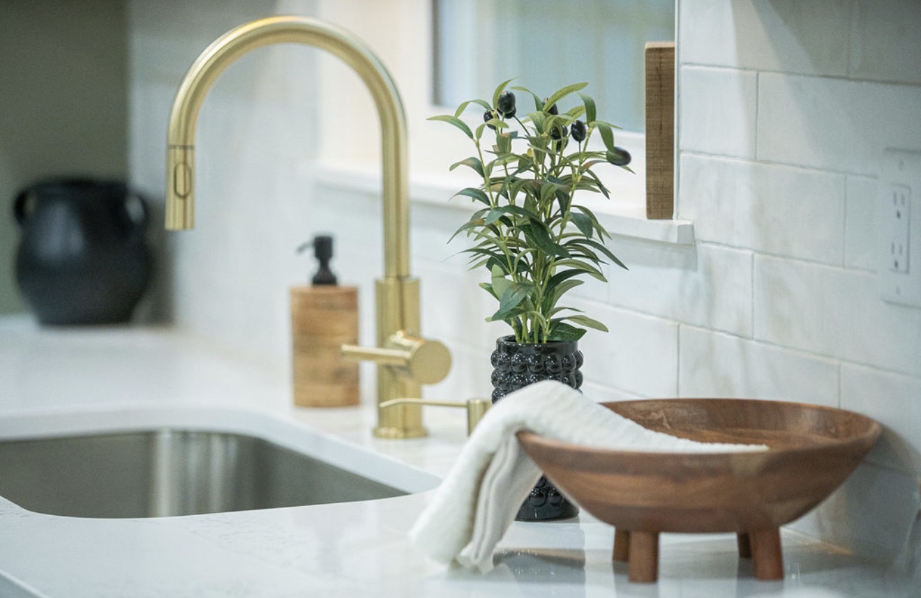 Kitchen sink detail with brushed brass faucet and handmade tile backsplash