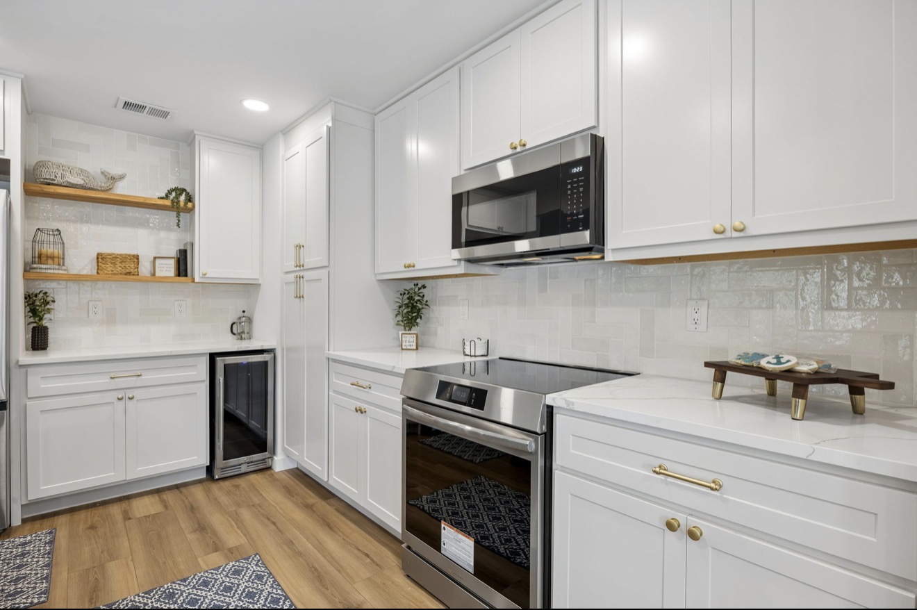 White shaker kitchen with quartz counters, glossy tile backsplash, and open wood shelving