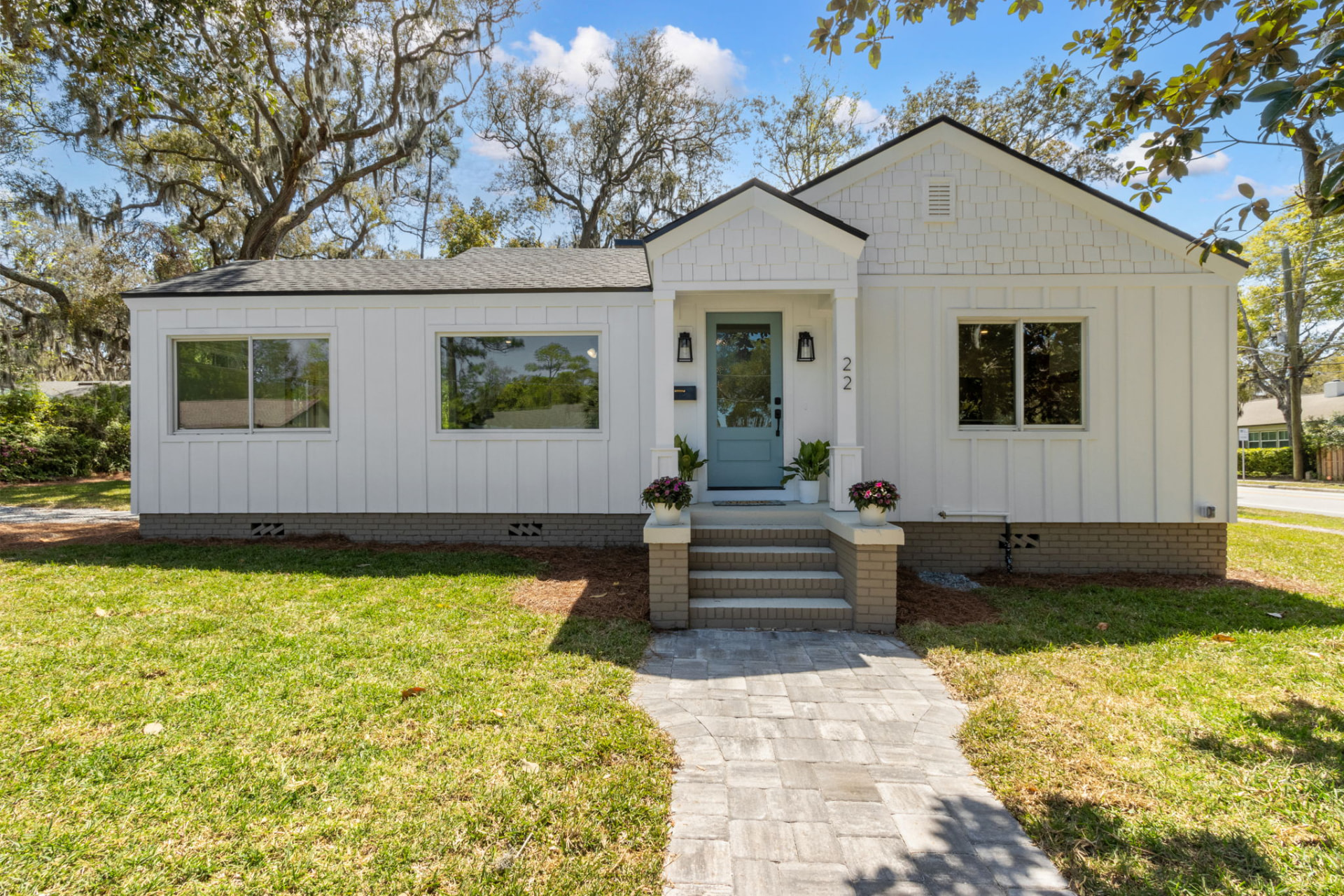 Front exterior of the renovated white board-and-batten home at Oak Grove Place, Fernandina Beach